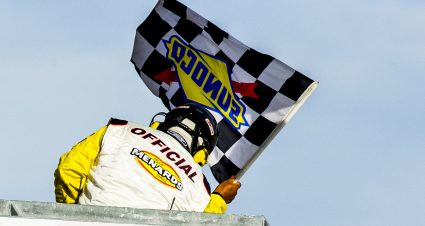 A race official waves the checkered flag to signal the end of the second ENEOS/Sunrise Ford Twins presented by West Coast Stock Car Hall of Fame race for the ARCA Menards Series West at the Utah Motorsports Campus in Tooele, Utah, on Saturday, June 27, 2020. (Isaac Hale/ARCA Racing)