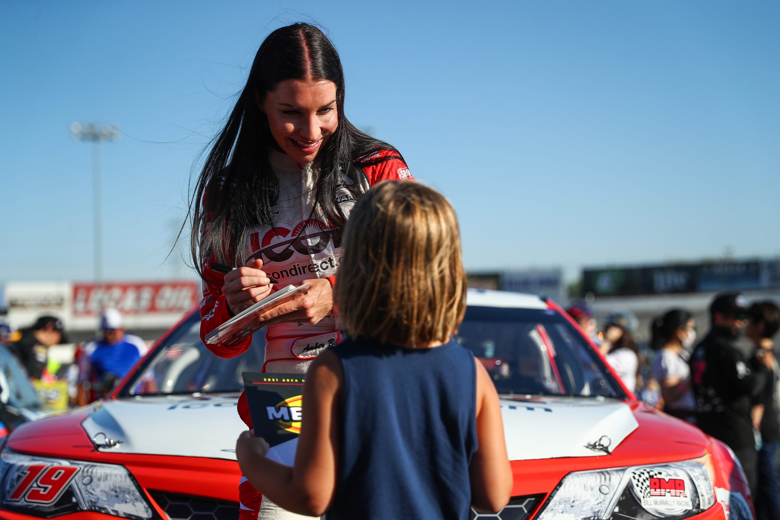 Amber Balcaen, driver of the #19 Icon Technologies Limited Toyota, signs autographs during the NAPA Auto Parts 150 for the ARCA Menards Series West at Irwindale Speedway in Irwindale, California on July 3, 2021. (Meg Oliphant/ARCA Racing)
